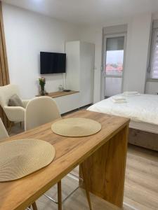 una camera con un letto e un tavolo con due sedie di Apartman Enigma a Ruma