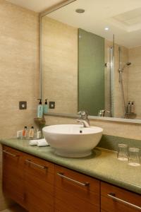 baño con lavabo y espejo grande en Atlantica Golden Beach Hotel - Adults Only, en Pafos