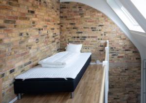 a bedroom with a brick wall with a bed in it at Hotell Havsporten in Karlholmsbruk