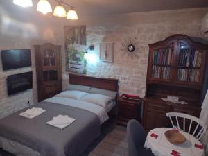 a bedroom with two beds and a table and a chair at Stone house next to Cluj-Napoca in Dezmir