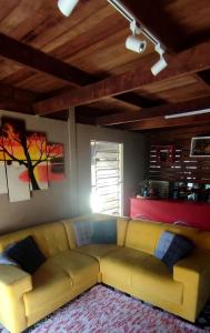 a living room with a yellow couch and a window at Ribeirinhos Hostel in Maués