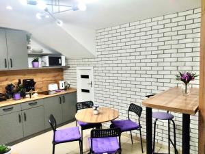 a kitchen with purple chairs and a wooden table at Like Home Hostel na Timiryazeva in Almaty