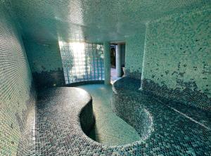 a room with a tub in a room with a window at Vista Grande Resort - A Gay Men's Resort in Palm Springs