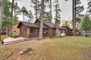 a cabin in the woods with a boat in the yard at Rustic Bemidji Cabin with Boat and Lake Access! in Bemidji