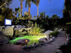 a garden with a pond with a waterfall at Vista Grande Resort - A Gay Men's Resort in Palm Springs