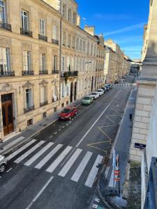 uma rua da cidade vazia com carros estacionados ao lado de edifícios em (A)Typique Chartrons em Bordeaux