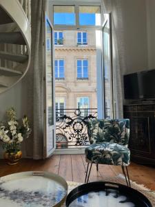 uma sala de estar com uma cadeira e uma grande janela em (A)Typique Chartrons em Bordeaux