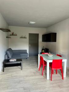 un soggiorno con tavolo e sedie rosse di À la Bouteucca a Fenis