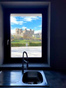 a kitchen sink with a window with a view of a castle at À la Bouteucca in Fenis