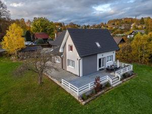 Casa blanca pequeña con terraza de madera en Domeček Janov en Janov