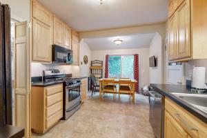 a kitchen with wooden cabinets and a table with a dining room at Cliff Retreat in Rockaway Beach