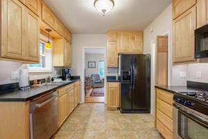 a kitchen with wooden cabinets and a stainless steel refrigerator at Cliff Retreat in Rockaway Beach +22 photos