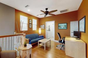 ein Wohnzimmer mit einem blauen Sofa und einem Schreibtisch in der Unterkunft Garden Castle in Tampa