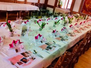 a long table with pink flowers in vases on it at Hotel-Restaurant Zum Loewen in Jestetten