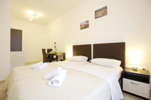 2 weiße Betten in einem Zimmer mit einem Tisch in der Unterkunft Sites Of Zadar Rooms in Zadar
