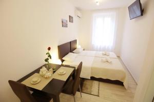 una camera con letto e tavolo con sala da pranzo di Sites Of Zadar Rooms a Zara (Zadar)