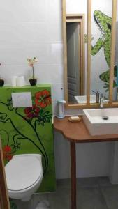 uma casa de banho com um WC, um lavatório e um espelho. em Magnifique vue mer sur baie de Malendure em Bouillante