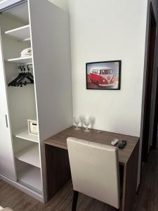 a room with a desk with a car on the wall at Suíte com varanda em Via Premiere - Rio centro in Rio de Janeiro