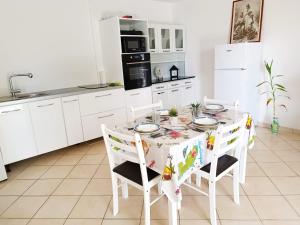 a white kitchen with a table and chairs at La belle Martinique in Sainte-Luce