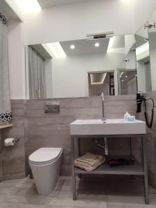 uma casa de banho com um lavatório, um WC e um espelho. em il sogno di afrodite luxury b and b em Roma
