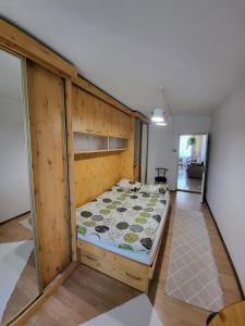 1 dormitorio con 1 cama con pared de madera en Квартира на Заньковецкой, en Uzhhorod