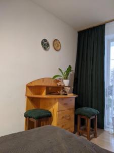 a bedroom with a wooden dresser and two stools at Квартира на Заньковецкой in Uzhhorod