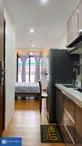 uma cozinha com um frigorífico e uma cama num quarto em Studio Tower by KR em Baguio
