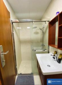 uma casa de banho com um chuveiro e um lavatório. em Studio Tower by KR em Baguio