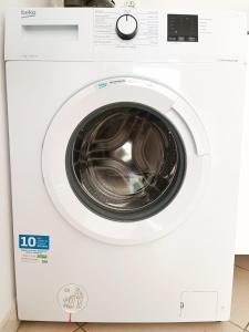 a white washing machine with its door open at La belle Martinique in Sainte-Luce