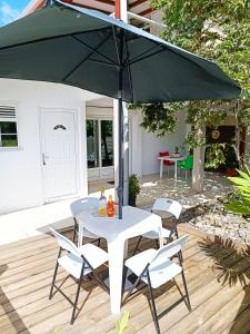 La belle Martinique في سانت لوسي: طاولة بيضاء وكراسي تحت مظلة خضراء