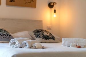 Una cama blanca con toallas encima. en La casa del Conte en Messina