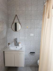 bagno con lavandino e specchio di La Posada Coliving a Viña del Mar