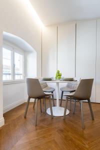 a white dining room with a table and chairs at UNYCA - Duomo Luxury View Florence in Florence