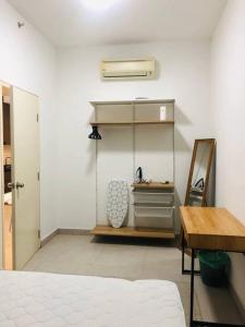 Zimmer mit einem Bett, einem Tisch und einem Spiegel in der Unterkunft The Maisonnette Homestay in Kajang