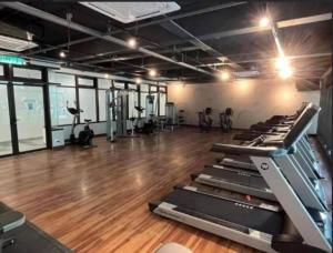 a gym with several treadmills and a wooden floor at The Maisonnette Homestay in Kajang
