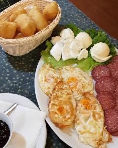 a plate of food with eggs and cheese and bread at Pansion Čarolija Vlašić in Šišava