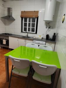 een keuken met een groene tafel en 4 stoelen bij Quinta da Ponte das Hortas 3 in Elvas