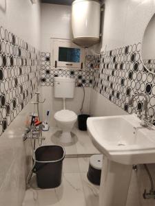 a white bathroom with a sink and a toilet at Farsal Villa in Srinagar