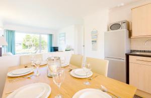 a dining room with a table with plates and wine glasses at 3 Europa Court, in Mawgan Porth