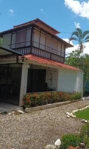 a house with a balcony on top of it at HOSPEDAJE TURÍSTICO CAMPESTRE "VILLA ALONDRA" Parqueo Privado! in Villavicencio