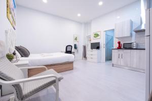 a white room with a bed and a kitchen at ABC Apartments Madrid in Madrid