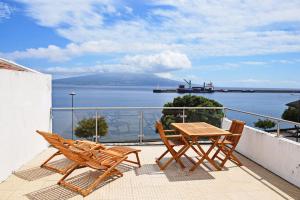 a table and chairs on a balcony with a view of the water at Casa da Paula in Horta