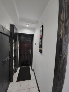 a hallway with a black door and a black rug at Новая квартира in Uzhhorod