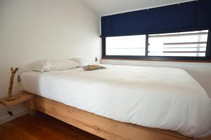 a bedroom with a large white bed with a window at Casa da Paula in Horta