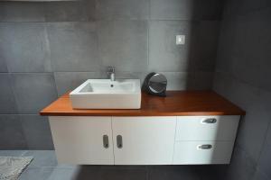 a bathroom counter with a sink and a mirror at Casa da Paula in Horta