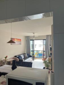 uma sala de estar com um sofá e uma mesa em Apartamento amplo a menos de 400 metros da praia localizado próximo a praça da Brunella, área nobre do Guarujá. no Guarujá