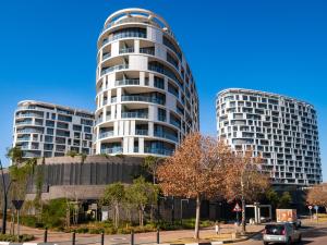 two tall buildings with cars parked in front of them at Executive Suite at Ellipse in Waterfall Midrand in Midrand