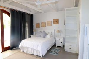 a bedroom with a white bed and a window at M & M Flat Arniston in Arniston