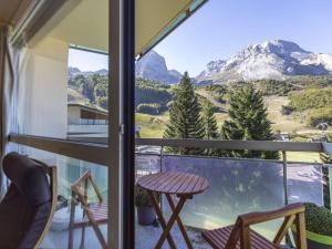 een balkon met een tafel en stoelen en uitzicht op een berg bij Studio cabine 6 personnes proche pistes, vue montagne - FR-1-400-38 in Gourette