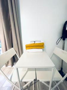 einen weißen Tisch und zwei Stühle in einem Zimmer in der Unterkunft Appart Parc monceau Arc triomphe - 2 pers in Paris